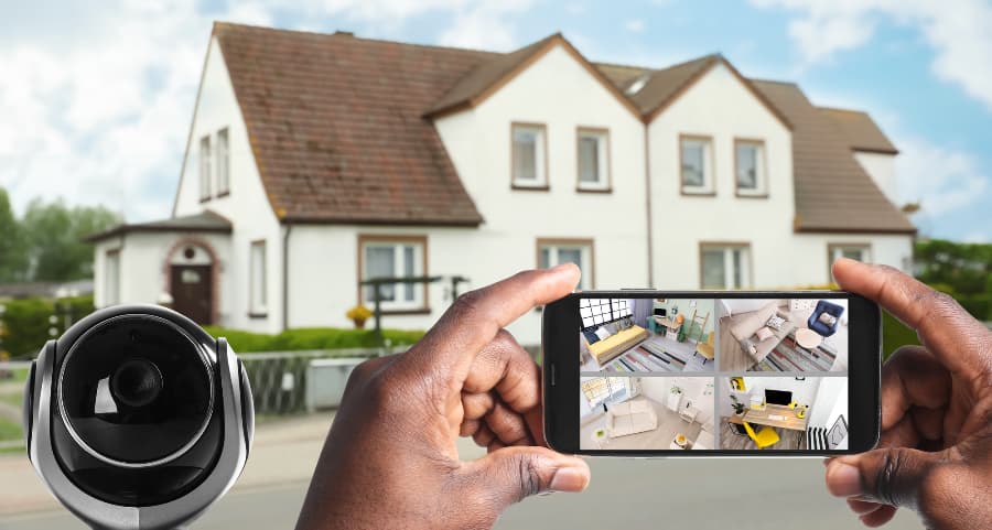 Man holding mobile device and checking footage from surveillance cameras